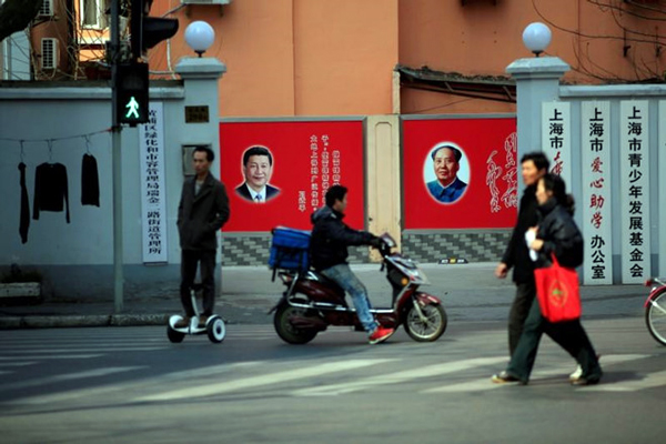 Người dân Trung Quốc trên đường phố với những tấm áp phích in hình Chủ tịch Tập Cận Bình và Chủ tịch Mao Trạch Đông