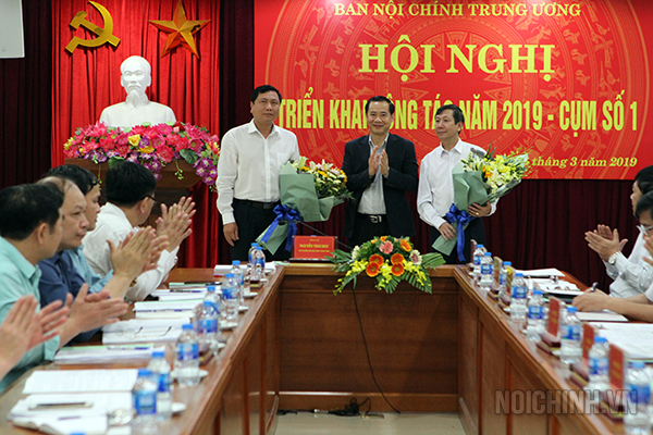 Đồng chí Nguyễn Thái Học, Phó trưởng Ban Nội chính Trung ương, Ủy viên Ban Chỉ đạo Cải cách tư pháp Trung ương tặng hoa chúc mừng đồng chí đại diện Cụm trưởng số 1 và Cụm phó năm 2019