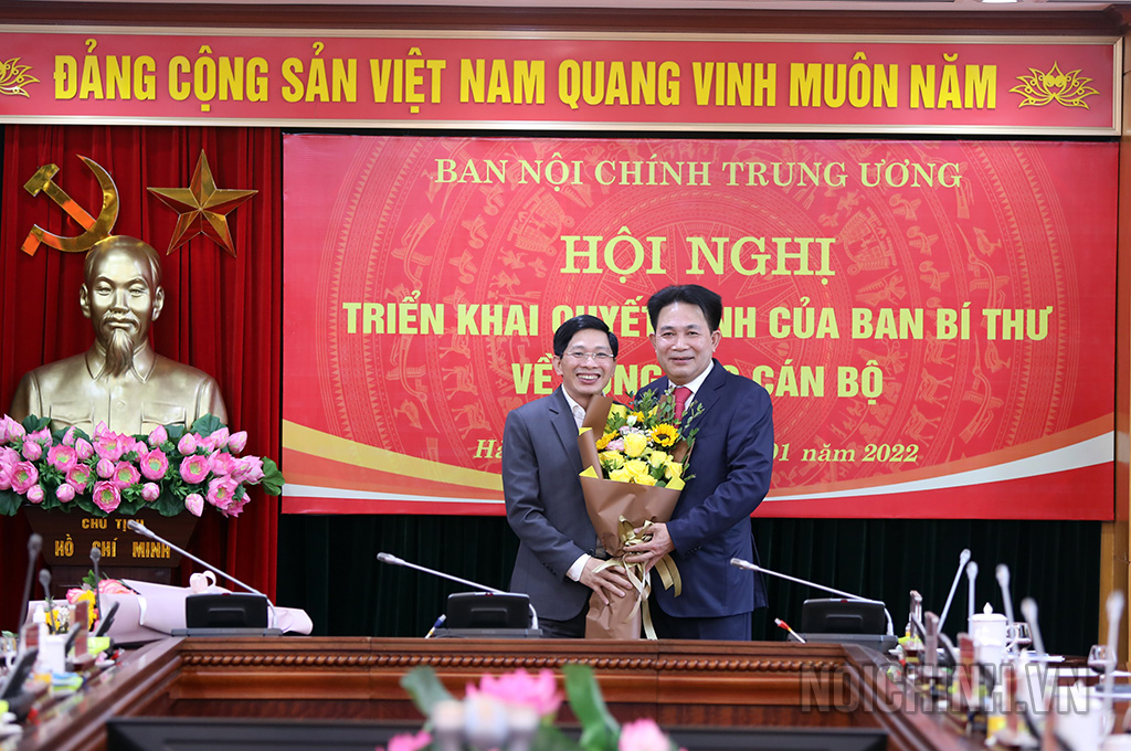 Đồng chí Đặng Văn Dũng, Trợ lý Trưởng Ban Nội chính Trung ương tặng hoa chúc mừng đồng chí Nguyễn Văn Yên