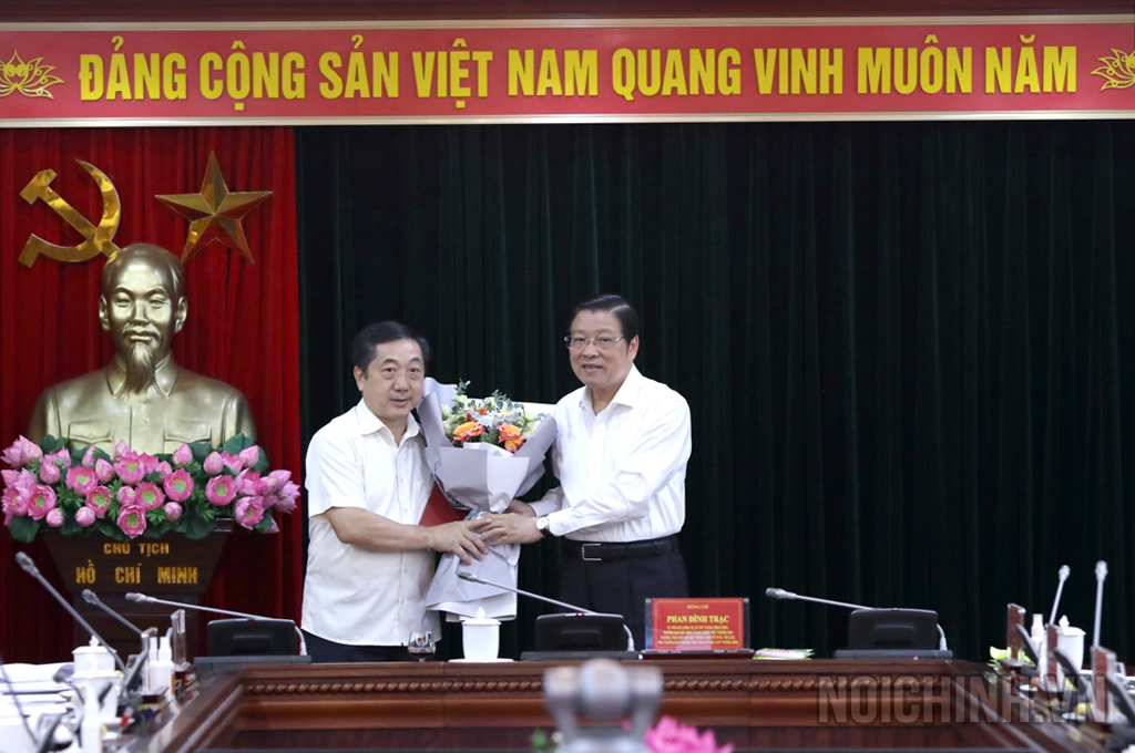 Đồng chí Phan Đình Trạc, Ủy viên Bộ Chính trị, Bí thư Trung ương Đảng, Trưởng Ban Nội chính Trung ương trao Quyết định và tặng hoa đồng chí Nguyễn Khắc Minh