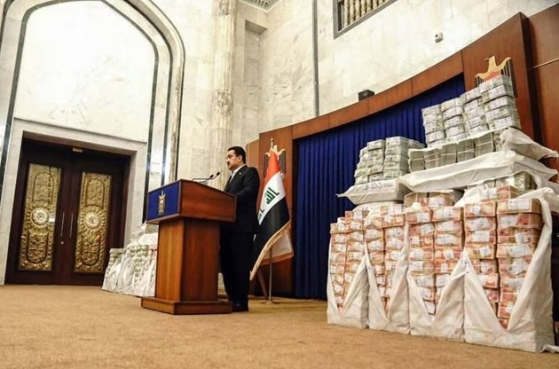 Thủ tướng Iraq Mohammed Shia Al Sudani đứng cạnh lượng tiền mặt rất lớn thu hồi được trong số 2,5 tỷ USD công quỹ bị thất thoát trong 