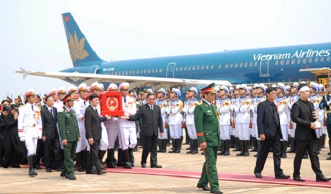 Chuyên cơ VN103 chở linh cữu Đại tướng Võ Nguyên Giáp hạ cánh an toàn xuống sân bay Đồng Hới. Trong ảnh: Chủ tịch nước Trương Tấn Sang; đồng chí Lê Hồng Anh, Ủy viên Bộ Chính trị, Thường trực Ban Bí thư; Ủy viên Bộ Chính trị, Trưởng Ban Tổ chức Trung ương Tô Huy Rứa; Ủy viên Bộ Chính trị, Phó Thủ tướng Nguyễn Xuân Phúc; Ủy viên Bộ Chính trị, Bộ trưởng Bộ Quốc phòng Phùng Quang Thanh cùng nâng linh cữu Đại tướng tiến về phía linh xa. Phía sau linh cữu là gia quyến của Đại tướng. Ảnh: VGP