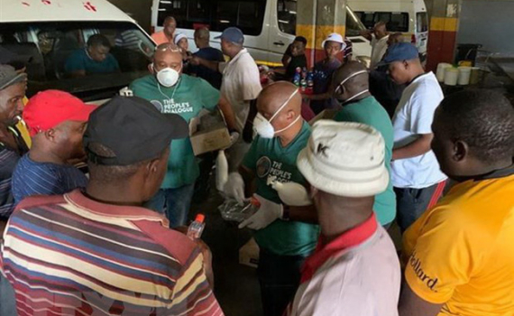 Nhân viên y tế phát dung dịch khử trùng tay tại một bến xe khách tại thủ đô Pretoria, Nam Phi