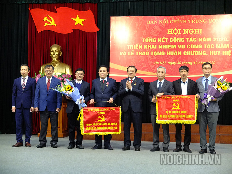  Đồng chí  Phan Đình Trạc, Bí thư Trung ương Đảng, Trưởng Ban Nội chính Trung ương trao Cờ Thi đua của Ban Nội chính Trung ương cho tập thể Vụ 1 và Vụ 4