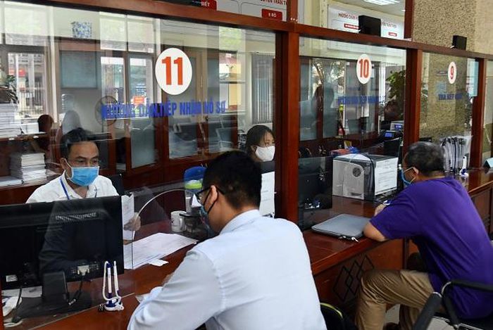 Cán bộ UBND thành phố Hà Nội tiếp nhận, hướng dẫn người dân làm thủ tục hành chính tại bộ phận “Một cửa”