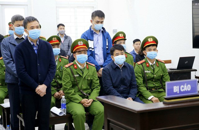 Bị cáo Nguyễn Đức Chung (ngồi) và 3 đồng phạm tại phiên xét xử tháng 12/2020. (Ảnh: TTXVN)