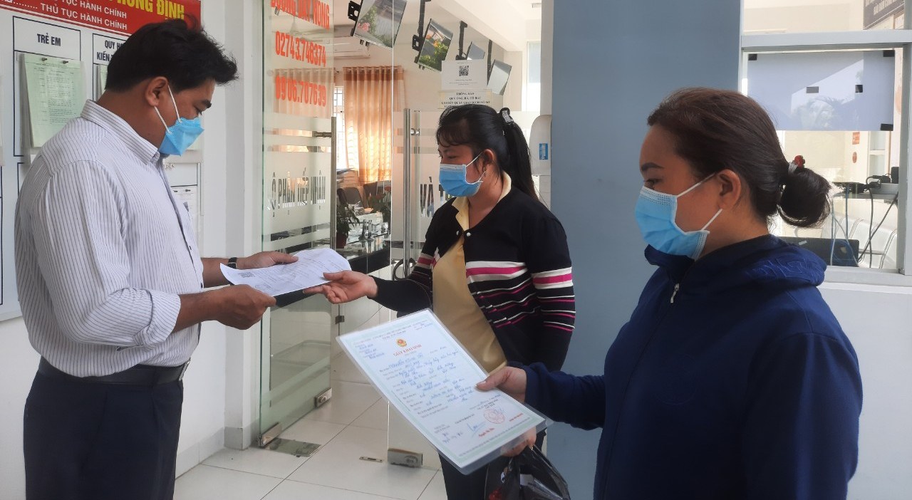 Cán bộ “một cửa” phường Hưng Định, thành phố Thuận An, tỉnh Bình Dương hướng dẫn người dân thực hiện hồ sơ trực tuyến