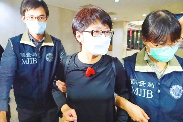 Bà Chen Hsin-yu (giữa ảnh) được các nhân viên Cục Điều tra Đài Bắc dẫn đi vào ngày 28/7. Ảnh: CNA