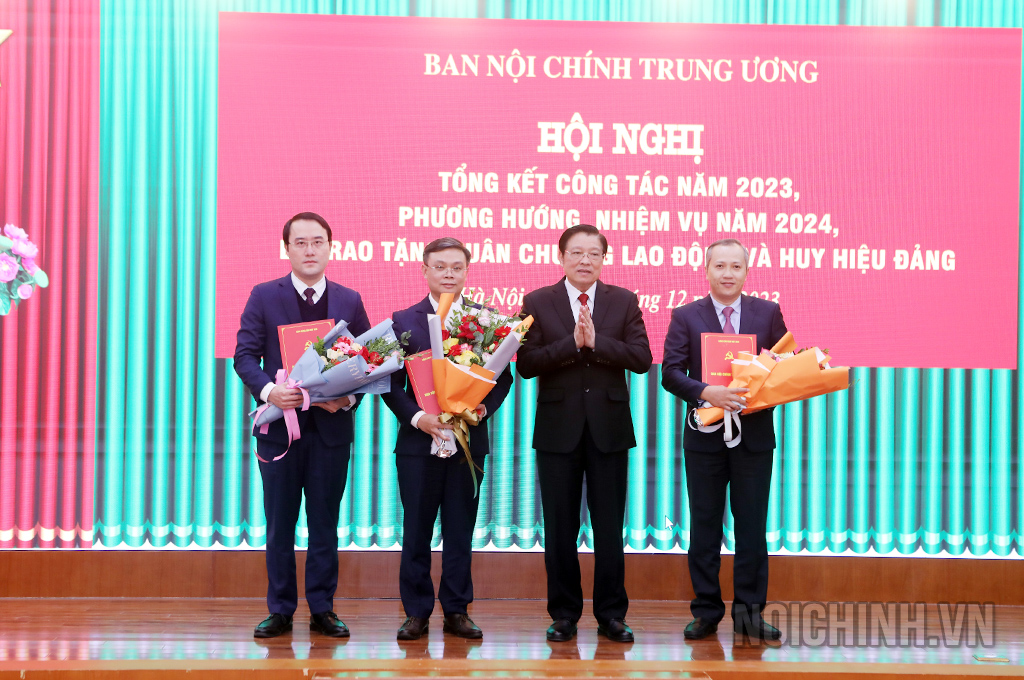 Đồng chí Phan Đình Trạc, Ủy viên Bộ Chính trị, Bí thư Trung ương Đảng, Trưởng Ban Nội chính Trung ương trao Quyết định bổ nhiệm và tặng hoa chúc mừng các đồng chí được bổ nhiệm