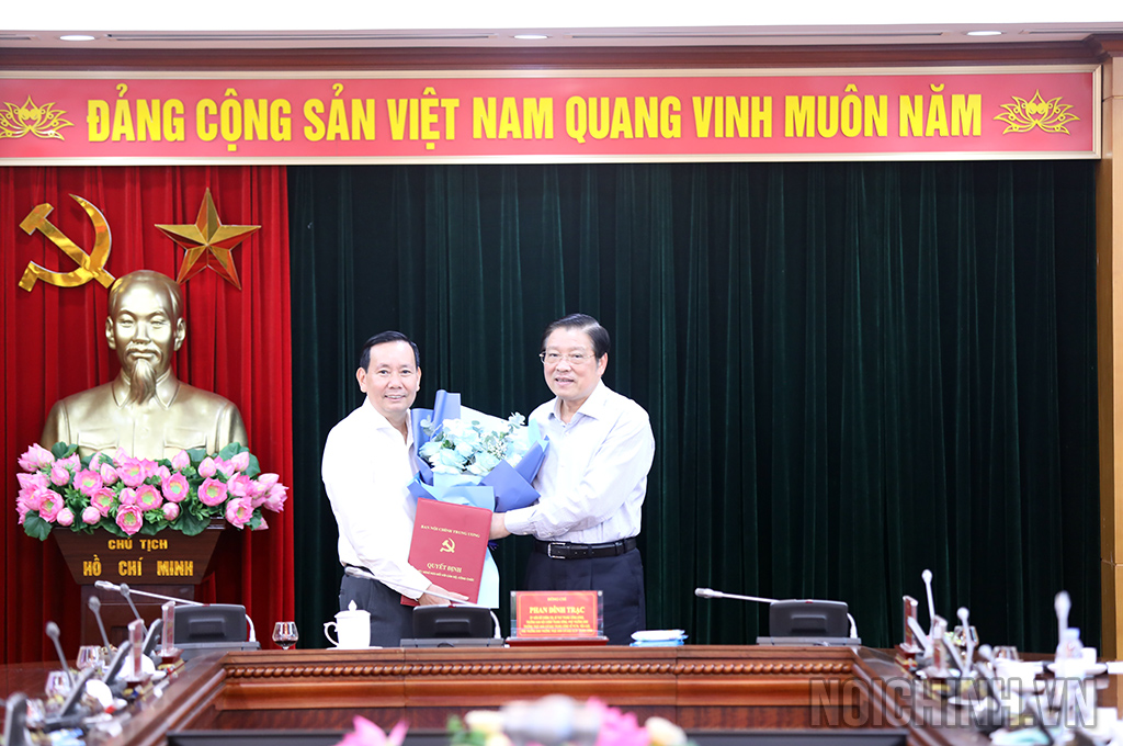 Đồng chí Phan Đình Trạc, Ủy viên Bộ Chính trị, Bí thư Trung ương Đảng, Trưởng Ban Nội chính Trung ương  trao Quyết định và tặng hoa chúc mừng đồng chí Đàm Văn Lợi