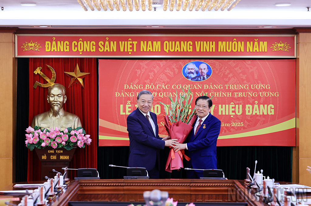 Đồng chí Tô Lâm, Tổng Bí thư Ban Chấp hành Đảng Cộng sản Việt Nam tặng hoa chúc mừng đồng chí Phan Đình Trạc, Ủy viên Bộ Chính trị, Bí thư Trung ương Đảng, Trưởng Ban Nội chính Trung ương 45 năm tuổi Đảng